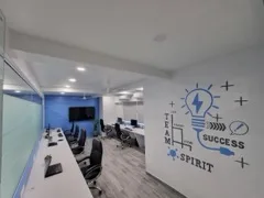 Developer workstations at the Adroit Infosol office, alongside a wall graphic reading Team Spirit and Success