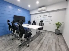 Adroit Infosol meeting room with a conference table, ergonomic chairs, wall-mounted display, and a Teamwork wall graphic