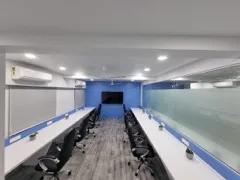 Open-plan work area at Adroit Infosol with two rows of desks and a wall-mounted display
